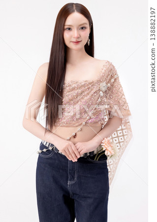Modern trendy Thai fashion woman wearing a traditional Sabai paired with denim jeans, reflecting the growing fashion trend in Thailand that blends cultural heritage with contemporary street style. Modern trendy Thai fashion woman wearing a traditional Sabai paired with denim jeans, reflecting the growing fashion trend in Thailand that blends cultural heritage with contemporary street style. 138882197