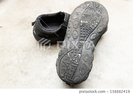 Worn-out black shoes; the soles are worn down; no consideration for safety. Worn-out black shoes; the soles are worn down; no consideration for safety. 138882419