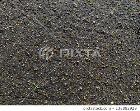 Close view of ground surface with dirt and small stones in natural setting during daylight hours 138882929