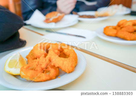 Crispy fried calamari rings shared on a table at a restaurant in Barcelona. 138883303