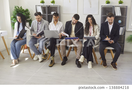 Business Team Seated In Row At Office Meeting Business Team Seated In Row At Office Meeting 138884218