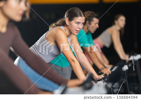 Athletic woman doing exercises on exercise bike Athletic woman doing exercises on exercise bike 138884394