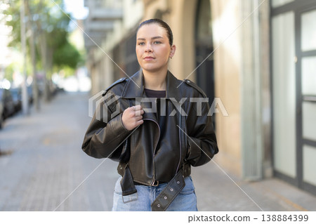 Young female tourist walks through a spring city and takes in sights Young female tourist walks through a spring city and takes in sights 138884399
