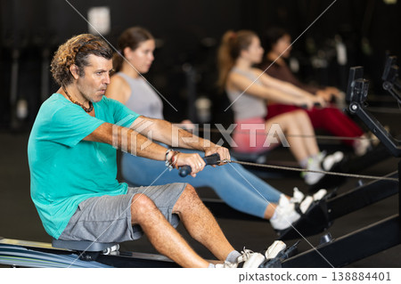 Man doing a workout on a rowing machine 138884401