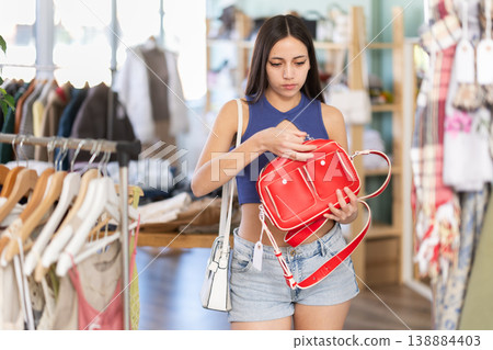 Young women choosing handbag in store Young women choosing handbag in store 138884403