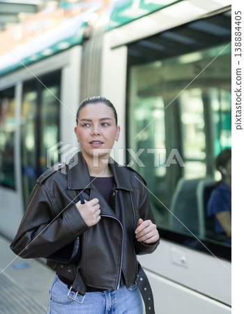 Young woman waiting for tram at public transport stop 138884405