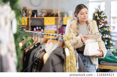 European girl near showcase pick out and buying handbag, New Year eve European girl near showcase pick out and buying handbag, New Year eve 138884423