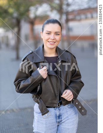 Young female tourist walks through a spring city and takes in sights Young female tourist walks through a spring city and takes in sights 138884425