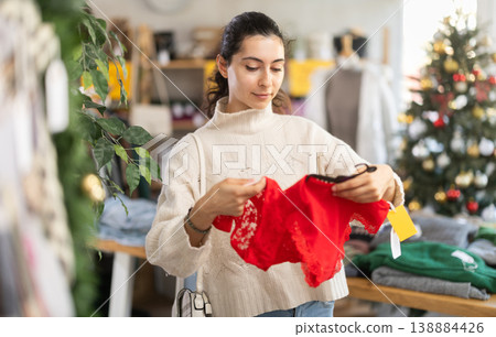 Happy young Armenian girl choosing red panties in clothing store 138884426