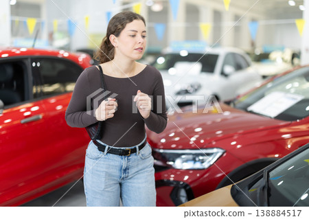 Young woman choosing car at auto dealership 138884517