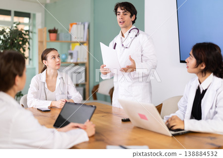 Young male doctor leading medical meeting in office Young male doctor leading medical meeting in office 138884532