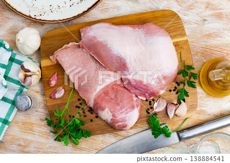 Raw pork secreto fillet and condiments prepared for roasting on wooden cutting board Raw pork secreto fillet and condiments prepared for roasting on wooden cutting board 138884541