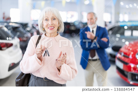 Senior woman is happy with a set of keys and the purchase of a new car Senior woman is happy with a set of keys and the purchase of a new car 138884547