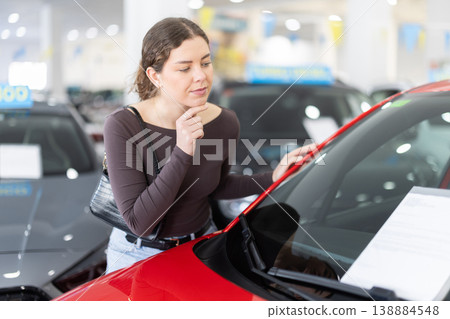 Young woman choosing car at auto dealership Young woman choosing car at auto dealership 138884548