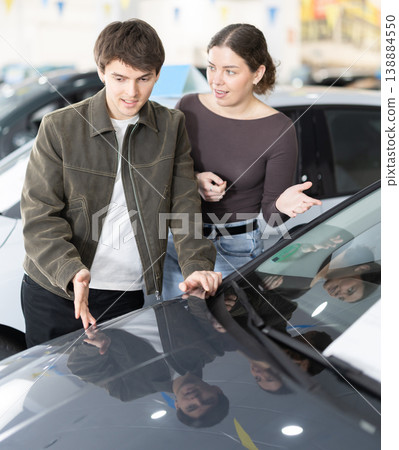 Young couple in a car dealership chooses a car 138884550