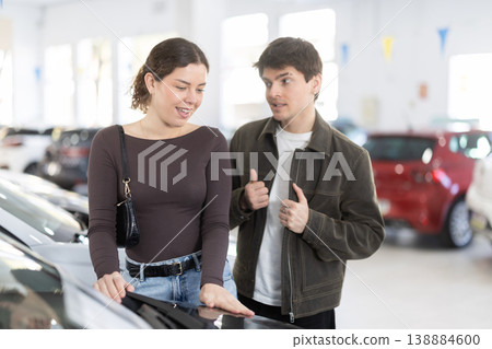 Young couple choosing car at auto dealership Young couple choosing car at auto dealership 138884600