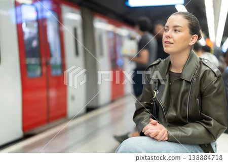 Young woman sitting at subway station Young woman sitting at subway station 138884718