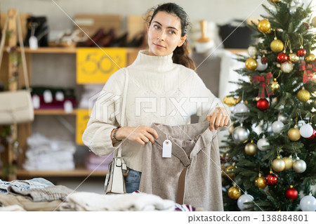 Armenian woman choosing warm pants in a store decorated for Christmas Armenian woman choosing warm pants in a store decorated for Christmas 138884801