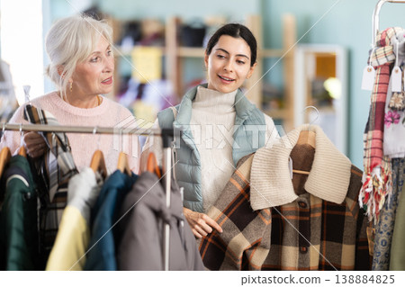 Two women of different ages choosing clothes in a store Two women of different ages choosing clothes in a store 138884825