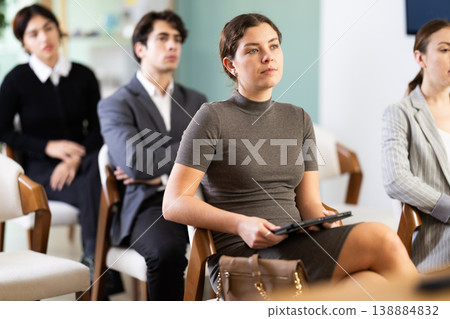 Portrait of pretty young girl student focused listening at lesson in university Portrait of pretty young girl student focused listening at lesson in university 138884832