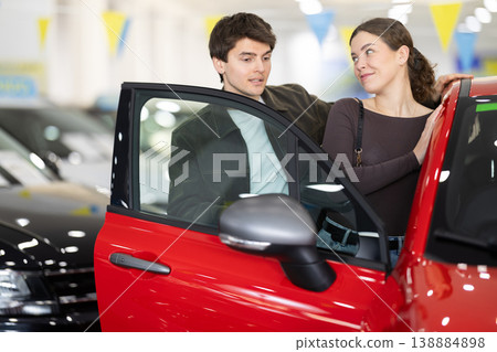 Young couple choosing car at auto dealership Young couple choosing car at auto dealership 138884898