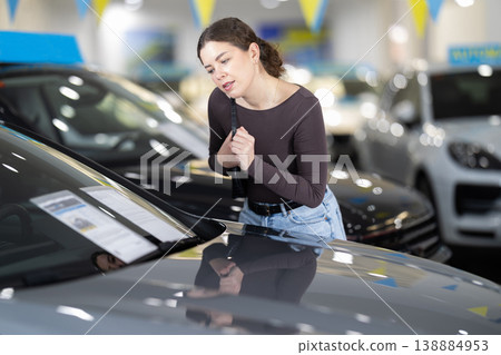 Young woman choosing car at auto dealership Young woman choosing car at auto dealership 138884953