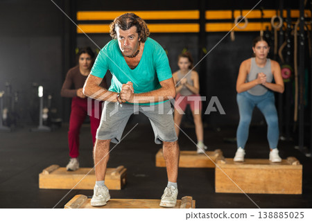 man at a Crossfit training steps on a box man at a Crossfit training steps on a box 138885025