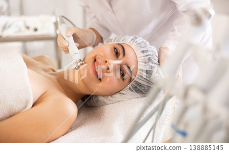 Female client getting face skin rf lifting procedure in cosmetic clinic Female client getting face skin rf lifting procedure in cosmetic clinic 138885145