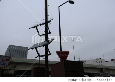 A residential street under a cloudy sky, where utility poles and power lines intersect. A residential street under a cloudy sky, where utility poles and power lines intersect. 138885152