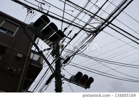 A quiet afternoon in a cloudy townscape with towering utility poles. A quiet afternoon in a cloudy townscape with towering utility poles. 138885189