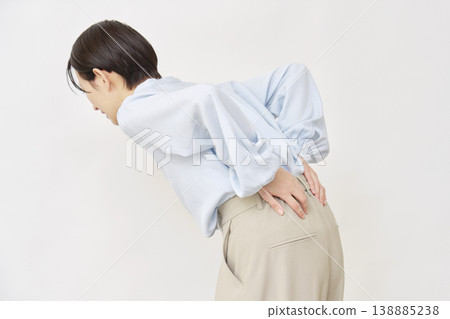 Woman in her 40s back pain white background Woman in her 40s back pain white background 138885238