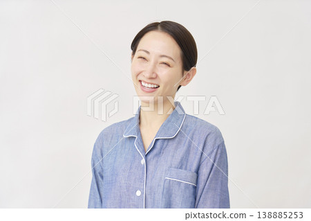 Woman in pajamas smiling white background Woman in pajamas smiling white background 138885253