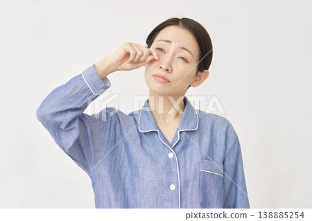 睡眠不足：身穿睡衣的女子揉眼睛，白色背景 138885254
