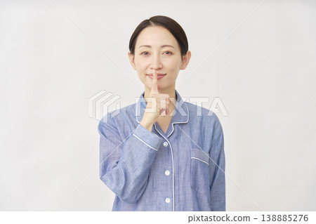 穿著睡衣的女人在白色背景上做出秘密手勢 138885276