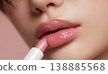 A close-up of a woman's lips as she applies lipstick to create an elegant look before going out. 138885568