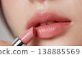 A close-up of a woman who meticulously applies lipstick to her lips before going out each day, creating a beautiful finish. 138885569