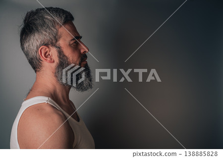 Man with gray beard looking to the side against a plain background Man with gray beard looking to the side against a plain background 138885828