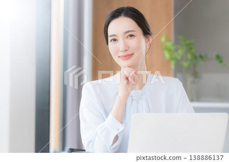 A positive-thinking, career-oriented woman working in a beautiful office, looking directly at the camera. A positive-thinking, career-oriented woman working in a beautiful office, looking directly at the camera. 138886137