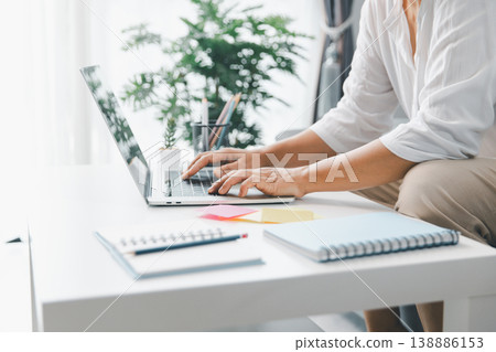 Hands typing on laptop at bright desk with sticky notes and notebook, home study workspace for online learning, homework planning, exam prep, productivity, focus, time management. study, online Hands typing on laptop at bright desk with sticky notes and notebook, home study workspace for online learning, homework planning, exam prep, productivity, focus, time management. study, online 138886153