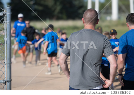 Kids enjoy a fun baseball practice with their coaches at a local park on a sunny afternoon in summer Kids enjoy a fun baseball practice with their coaches at a local park on a sunny afternoon in summer 138886302