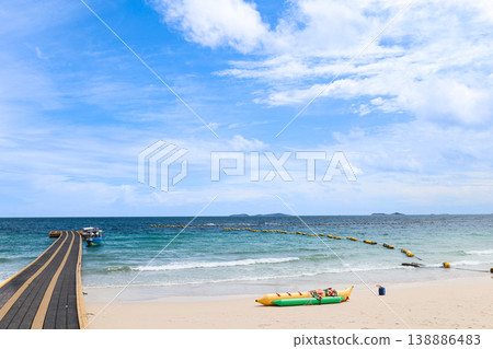 A beach and floating pier under a clear blue sky 138886483