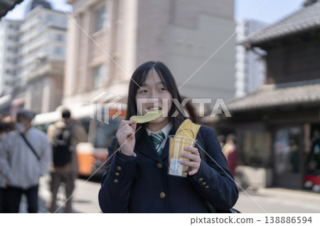 身穿校服的女學生們正在享用當地特產-地瓜片。 身穿校服的女學生們正在享用當地特產-地瓜片。 138886594