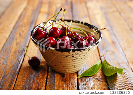 Fresh sweet cherries bowl on wooden background, top view. Space for text 138886830