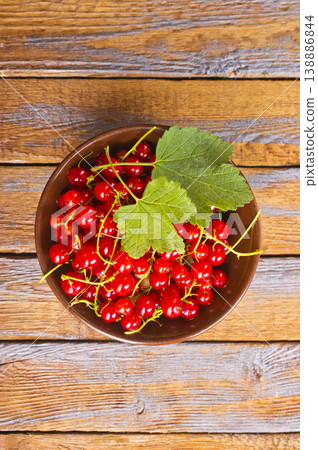 Red currant berries, fresh ripe and raw redcurrants in a wooden bowl on a table 138886844