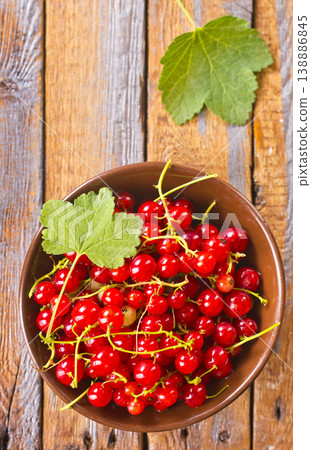 Red currant berries, fresh ripe and raw redcurrants in a wooden bowl on a table 138886845