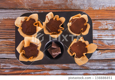 Chocolate cupcake with chocolate drops. Rustic wood background Chocolate cupcake with chocolate drops. Rustic wood background 138886851