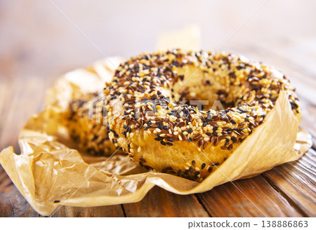 Overhead view of freshly baked bagels a table, top view of homemade bagels on paper Overhead view of freshly baked bagels a table, top view of homemade bagels on paper 138886863
