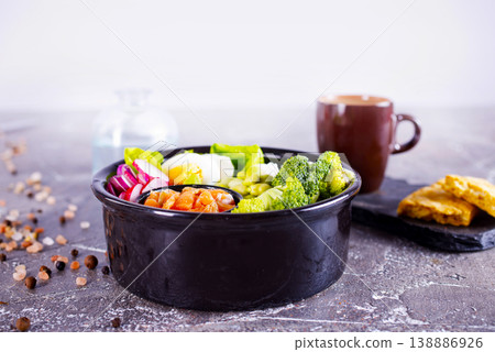 Salmon bowl with spinach, rice, avocado, tomato, cucumbers on a white background, top view. Salmon bowl with spinach, rice, avocado, tomato, cucumbers on a white background, top view. 138886926