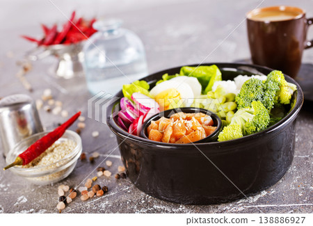 Salmon bowl with spinach, rice, avocado, tomato, cucumbers on a white background, top view. 138886927