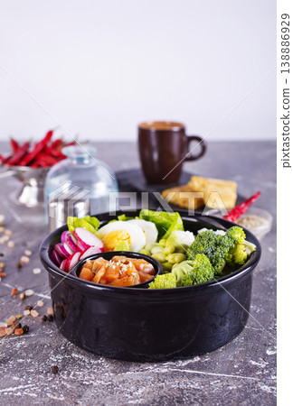 Salmon bowl with spinach, rice, avocado, tomato, cucumbers on a white background, top view. 138886929